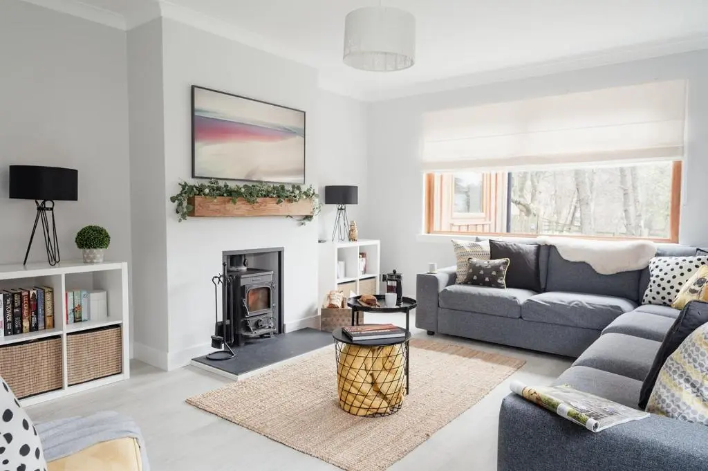 a living room with a couch and a fireplace at Gardeners Cottage - Seasgair Lodges in Aviemore