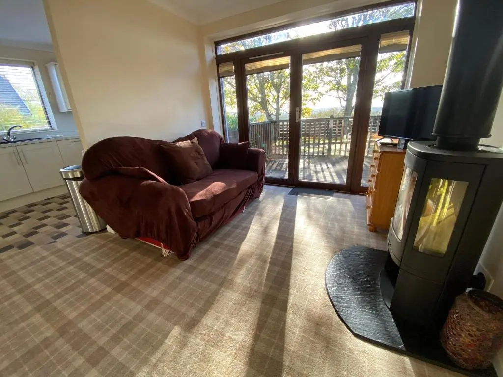 a living room with a couch and a fireplace at The Lodge at Woodend in Kemnay