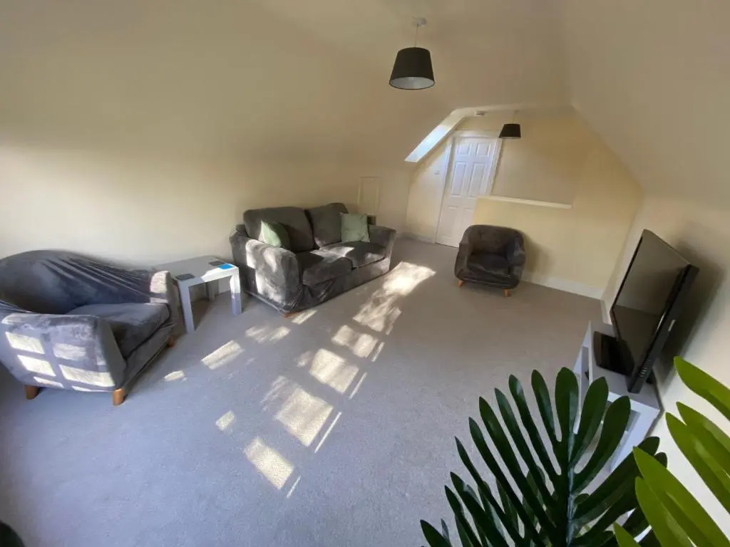 a living room with two couches and a television at The Lodge at Woodend in Kemnay