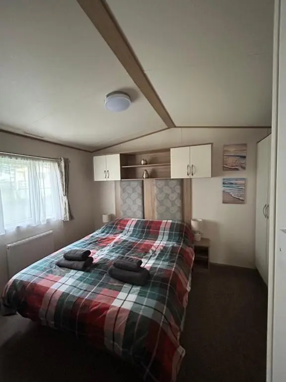 a bedroom with a bed with two towels on it at Uisge Beatha in Dornoch