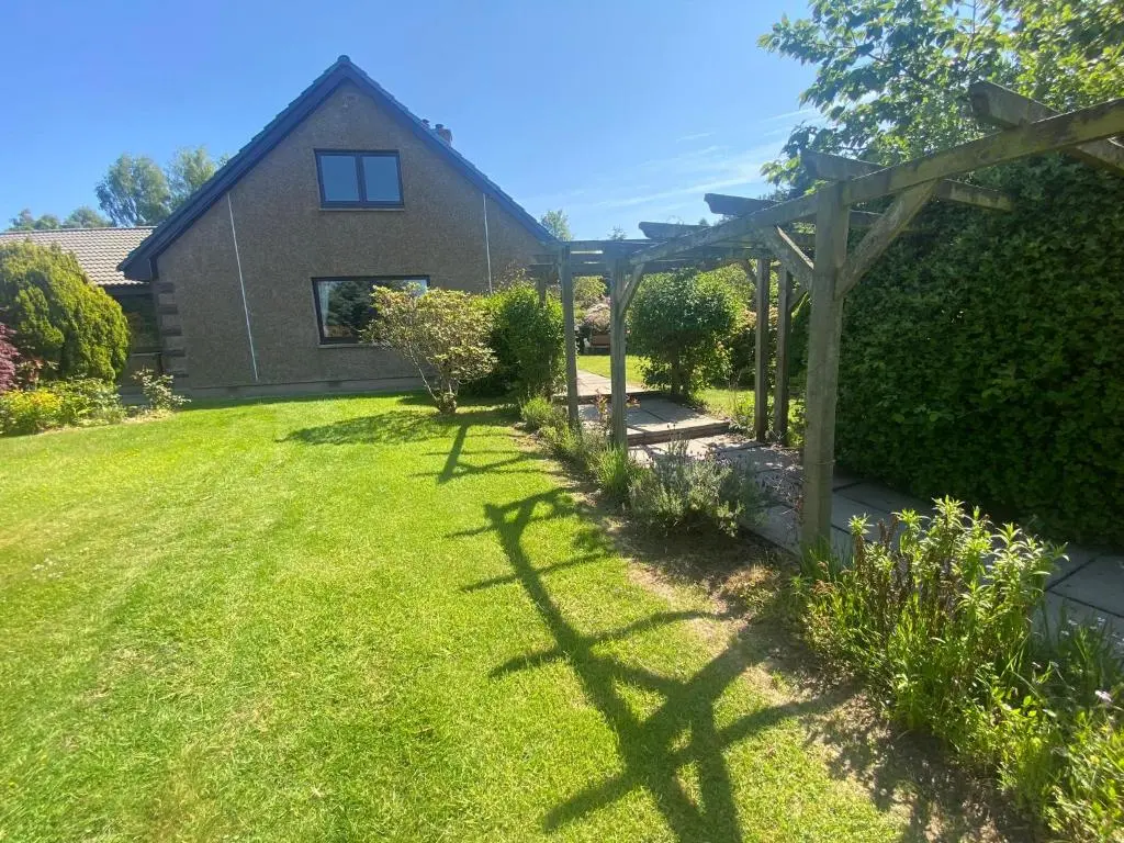 a garden with a wooden pergola and a house at Drummond House - Pets welcome free, 3 acres of gardens, free parking in Brackley