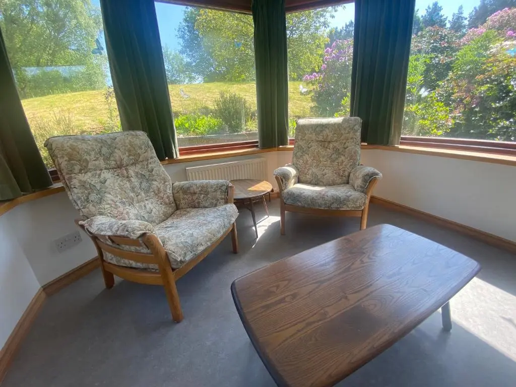two chairs and a table in a room with windows at Drummond House - Pets welcome free, 3 acres of gardens, free parking in Brackley