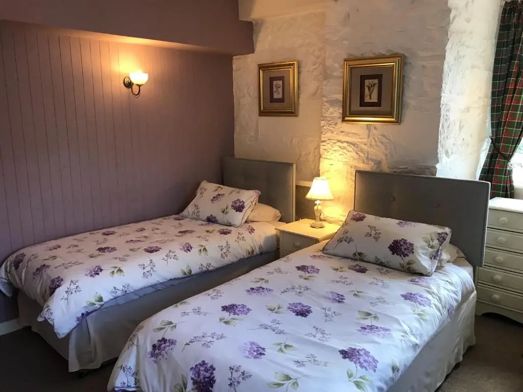 a bedroom with two beds and a window at The Struan Inn Self Catering Lodge in Struan