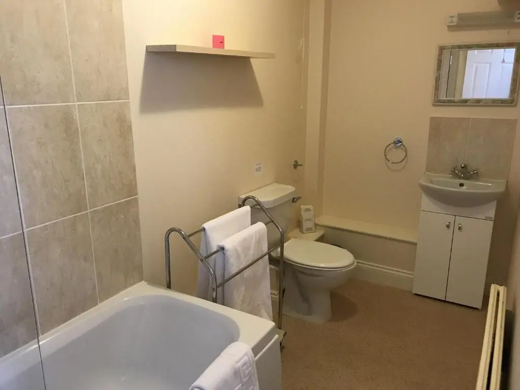 a bathroom with a tub and a toilet and a sink at The Struan Inn Self Catering Lodge in Struan