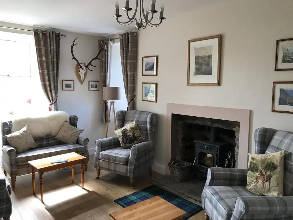 a living room with two couches and a fireplace at The Struan Inn Self Catering Lodge in Struan