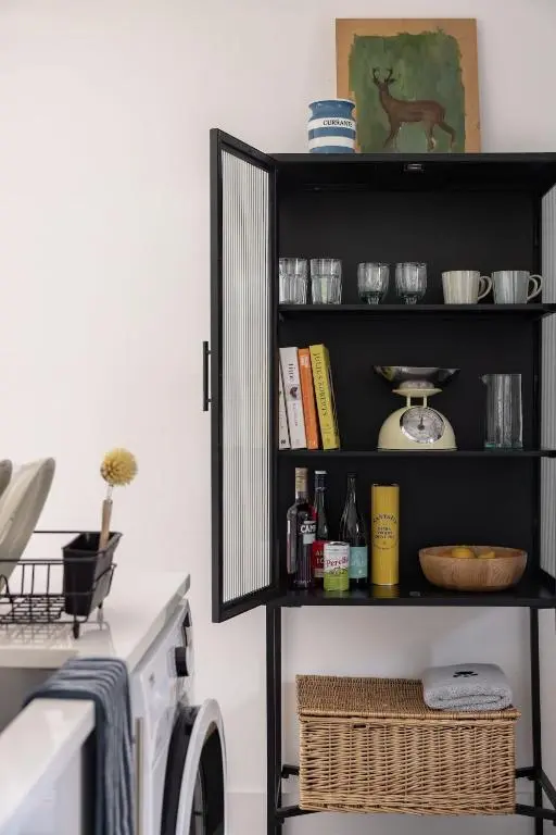 a black shelf in a laundry room with a washing machine at Number 5 Steading Cottage in Banchory