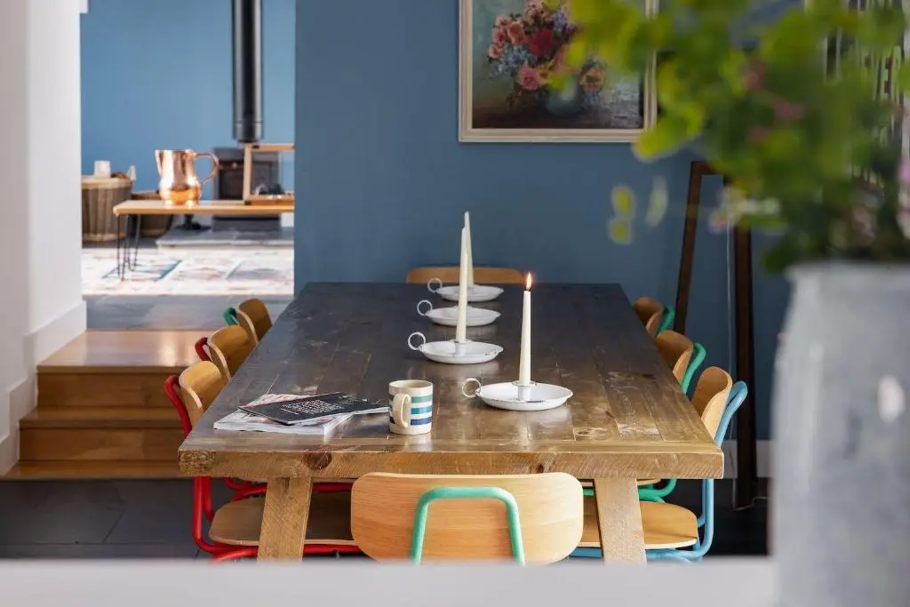a wooden table with chairs and a table with two candles at Number 5 Steading Cottage in Banchory