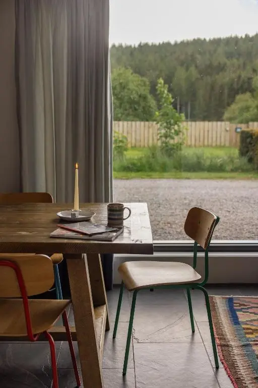 a dining room table with chairs and a window at Number 5 Steading Cottage in Banchory