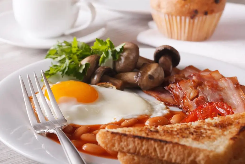 a plate of breakfast food with eggs sausage beans and mushrooms at The Royal Hotel in Ullapool