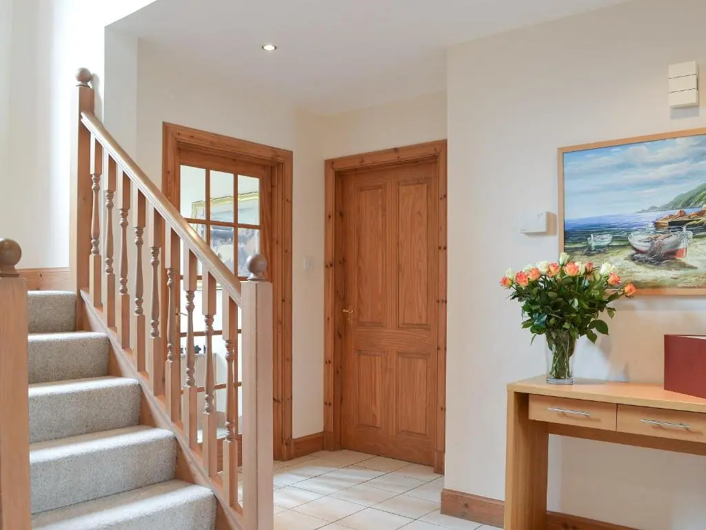 a staircase in a house with a vase of flowers at 3 Allt Mor in Aviemore