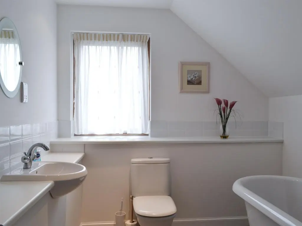 a white bathroom with a toilet and a sink at 3 Allt Mor in Aviemore