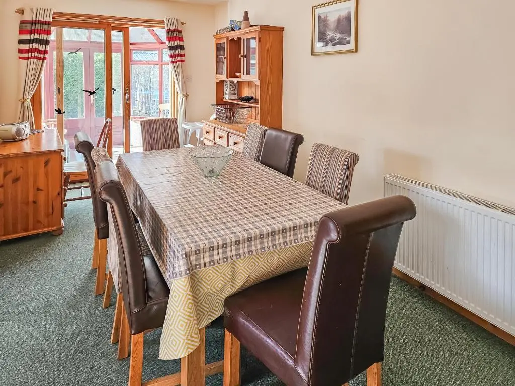 a dining room table and chairs with a table and a table at Cotterton Beag in Nethy Bridge