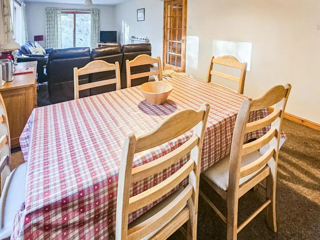 a dining room table and chairs with a checkered table cloth at Clunymhore in Nethy Bridge
