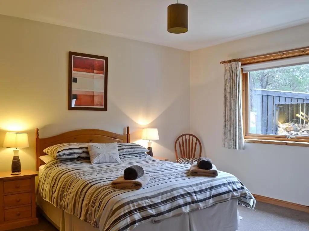 a bedroom with a bed with two towels on it at Clunymhore in Nethy Bridge