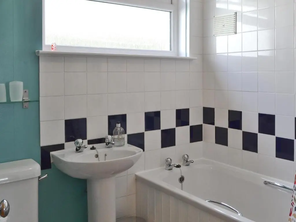 a bathroom with a sink and a tub and a toilet at Caberfeidh in Skye of Curr