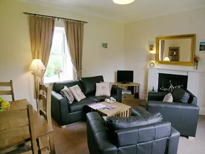 a living room with a couch and a table at Lockside Lower Flat in Fort Augustus