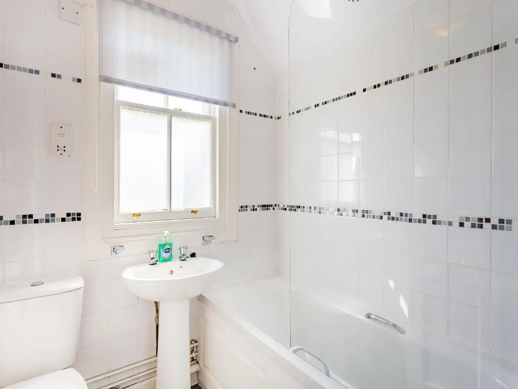 a white bathroom with a sink and a toilet and a tub at Lockview Upper Flat in Fort Augustus