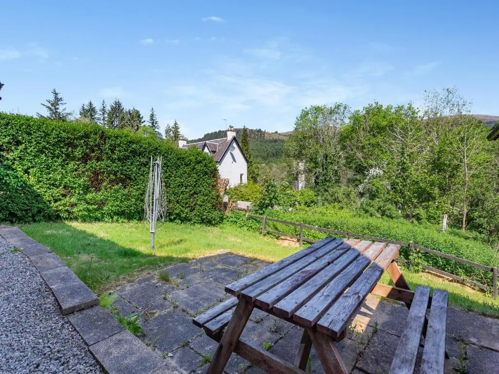 a wooden picnic table sitting on top of a yard at Lockview Upper Flat in Fort Augustus