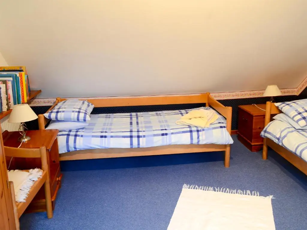 a small bedroom with two beds and a table at Culcharry Cottage in Cawdor
