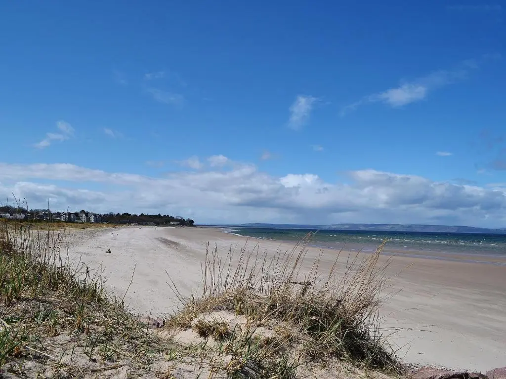 a sandy beach with the ocean in the background at Craigellachie Cottage in Croy