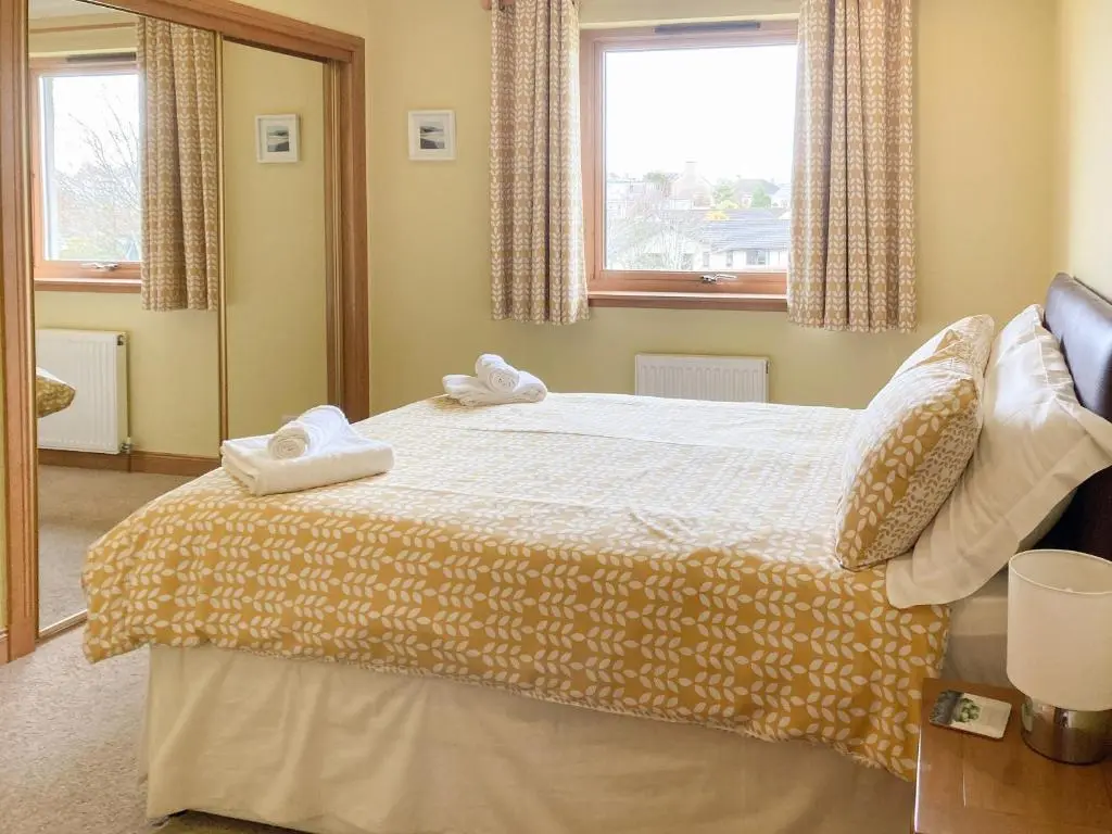a bedroom with a bed with two towels on it at Sandy Beach in Nairn