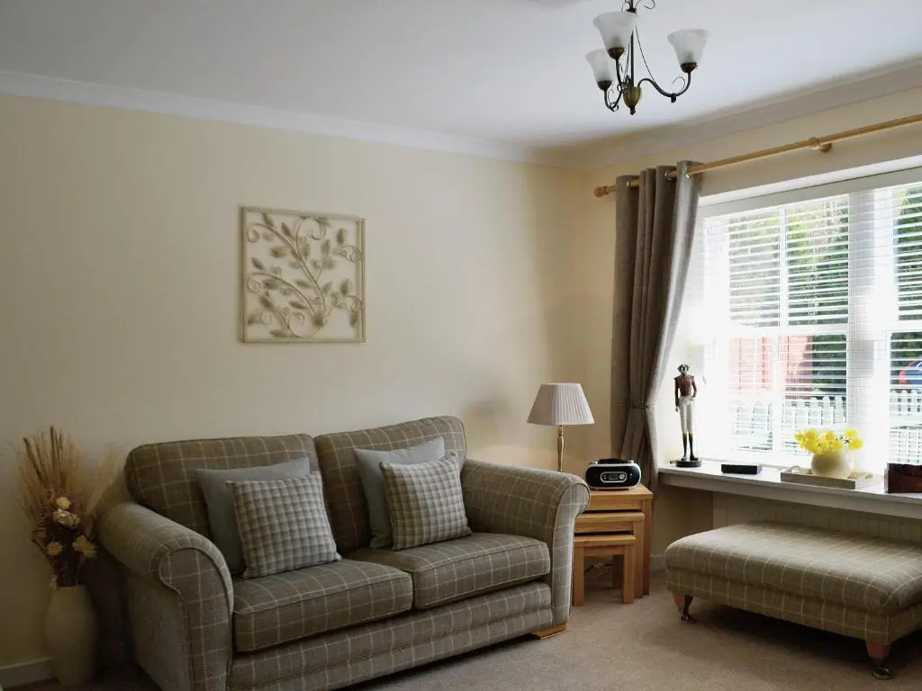 a living room with a couch and a window at Song Bird Cottage in Lochend