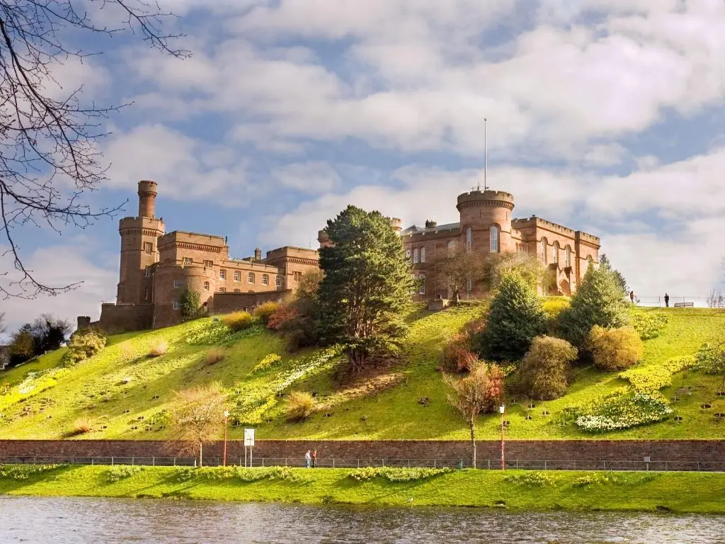 a castle on top of a hill next to a body of water at The Townhouse in Inverness