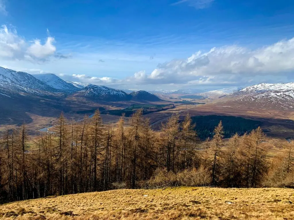 a view of a valley with snow covered mountains at Squirrel View in Newtonmore