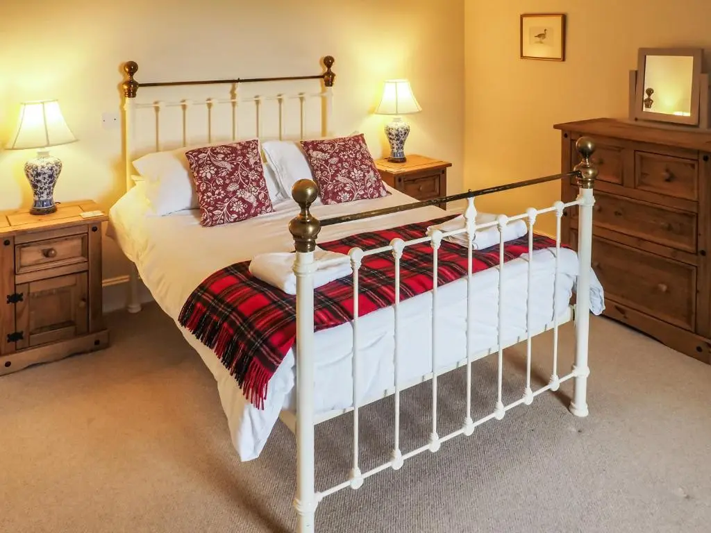 a bedroom with a bed and two night stands at Einich in Newtonmore