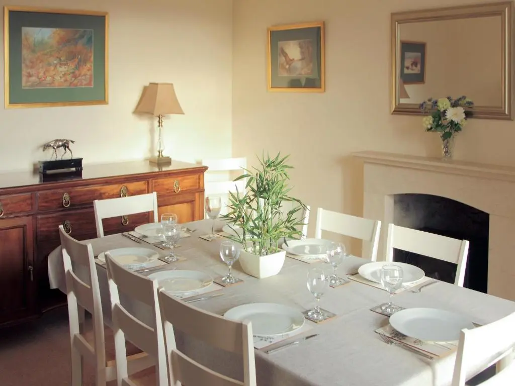 a dining room with a table with white plates and chairs at Einich in Newtonmore