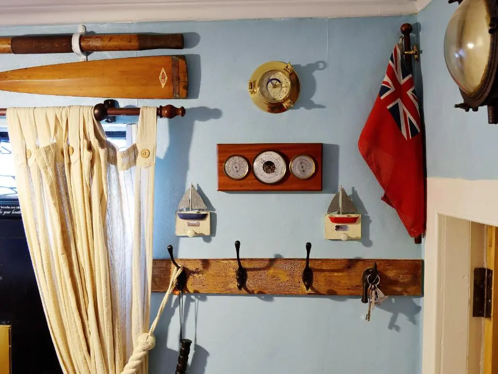 a wall with clocks and a flag on a ship at Boatmans Cottage - 27787 in Portessie