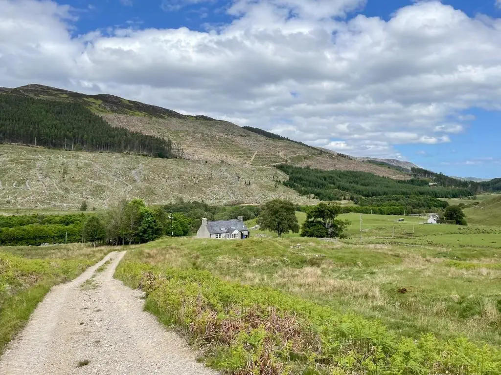 a dirt road leading to a house in a field at Glacour Studio Cottage in Bridgend