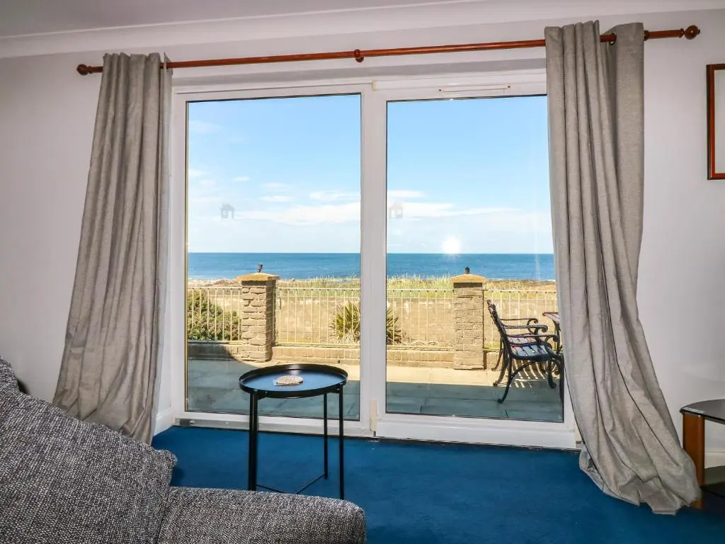 a living room with a view of the ocean at Shoreline House in Fraserburgh