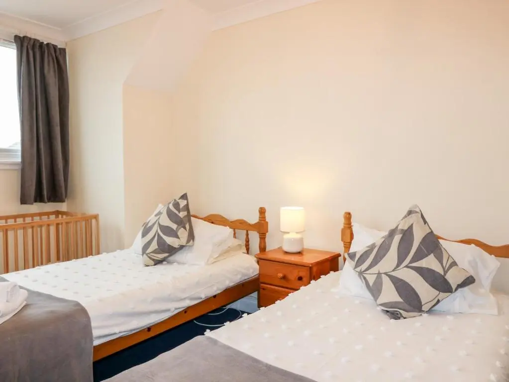a bedroom with two beds and a window at Shoreline House in Fraserburgh