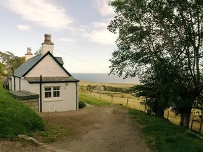 a small white house on the side of a road at Owl Cottage in Kilmote