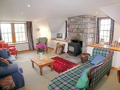 a living room with a couch and a fireplace at The Cottage in Ankerville