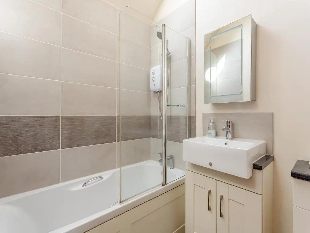 a bathroom with a shower and a sink and a tub at The Coyles Cottage - Sbh in Ballater