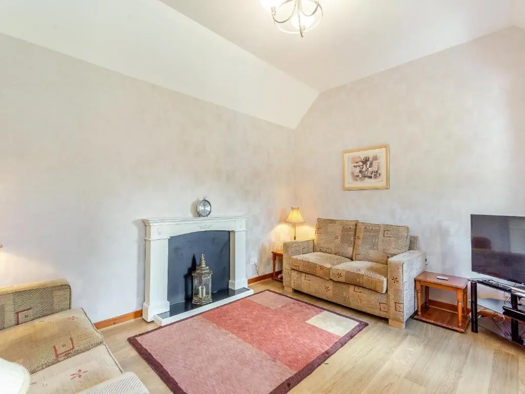 a living room with a couch and a fireplace at The Coyles Cottage - Sbh in Ballater