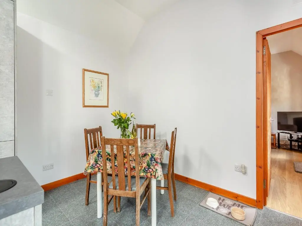 a dining room with a table and two chairs at The Coyles Cottage - Sbh in Ballater