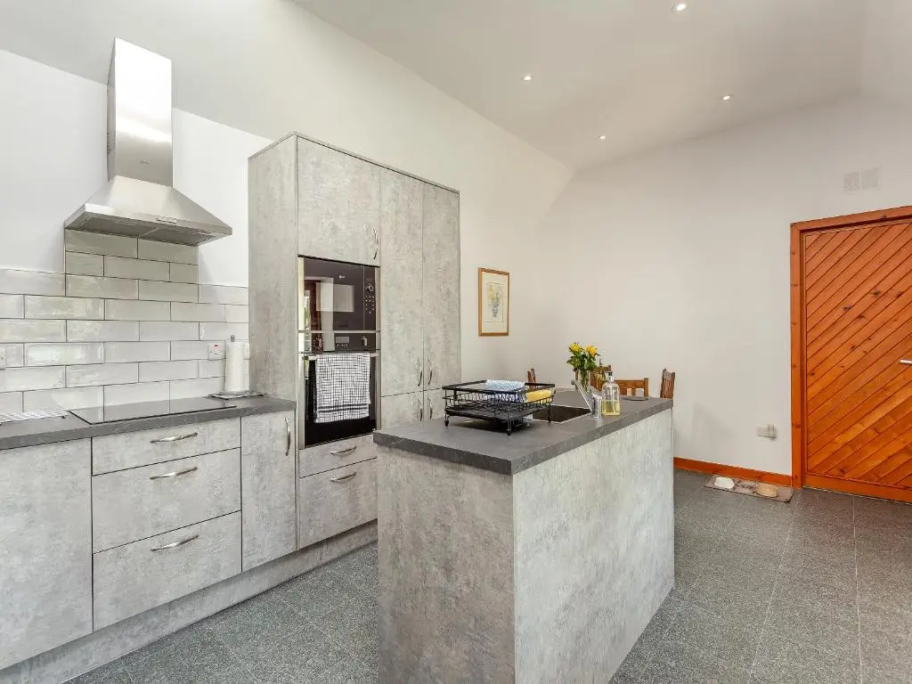 a kitchen with a counter and a stove in it at The Coyles Cottage - Sbh in Ballater
