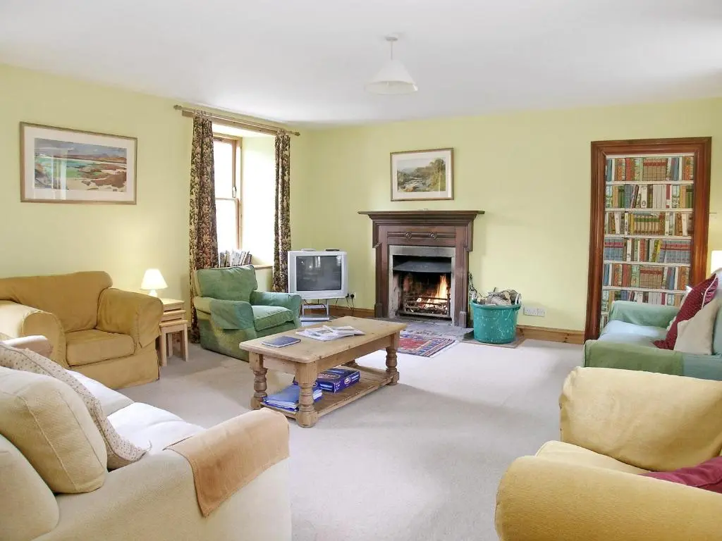 a living room filled with furniture and a fireplace at Mar House in Braemar