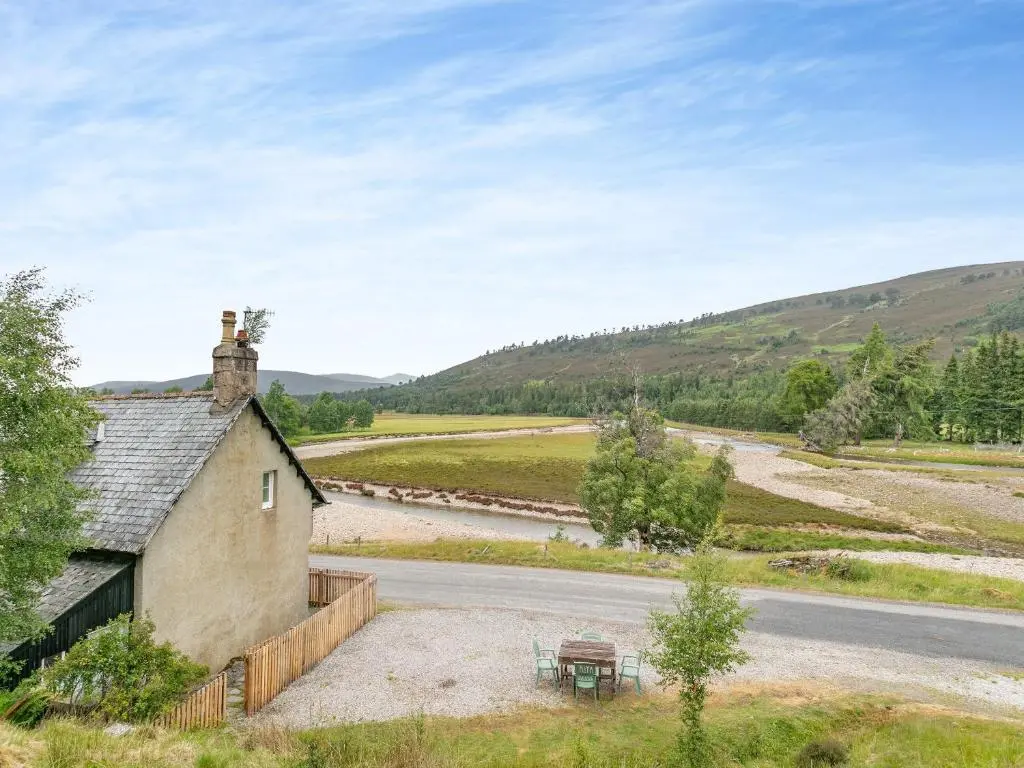 an old house with a picnic table next to a road at Meall Darroch in Inverey