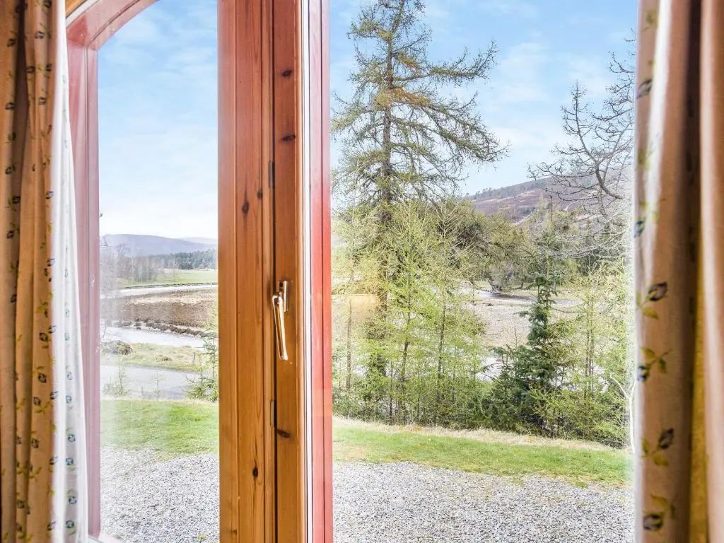 an open window with a view of a field at Stuffer's Cottage in Inverey
