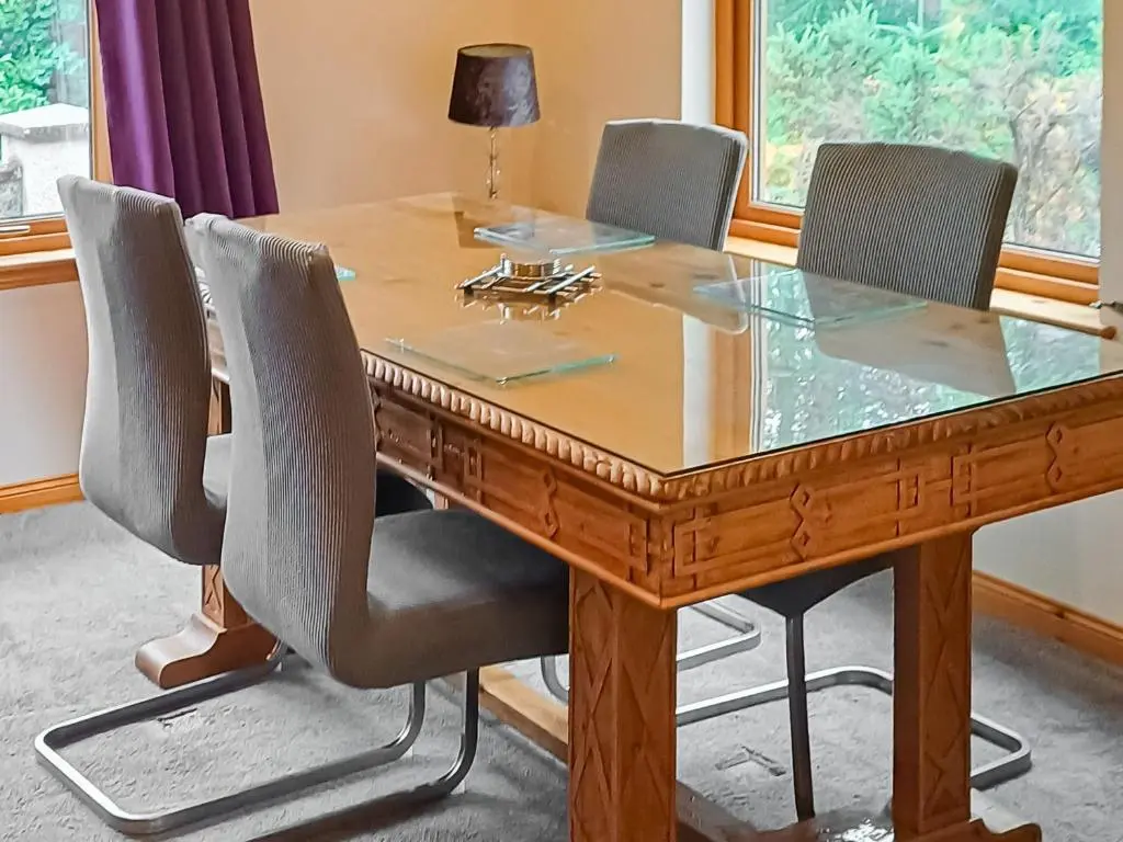 a wooden table with four chairs around it at Park Lodge in Strachan