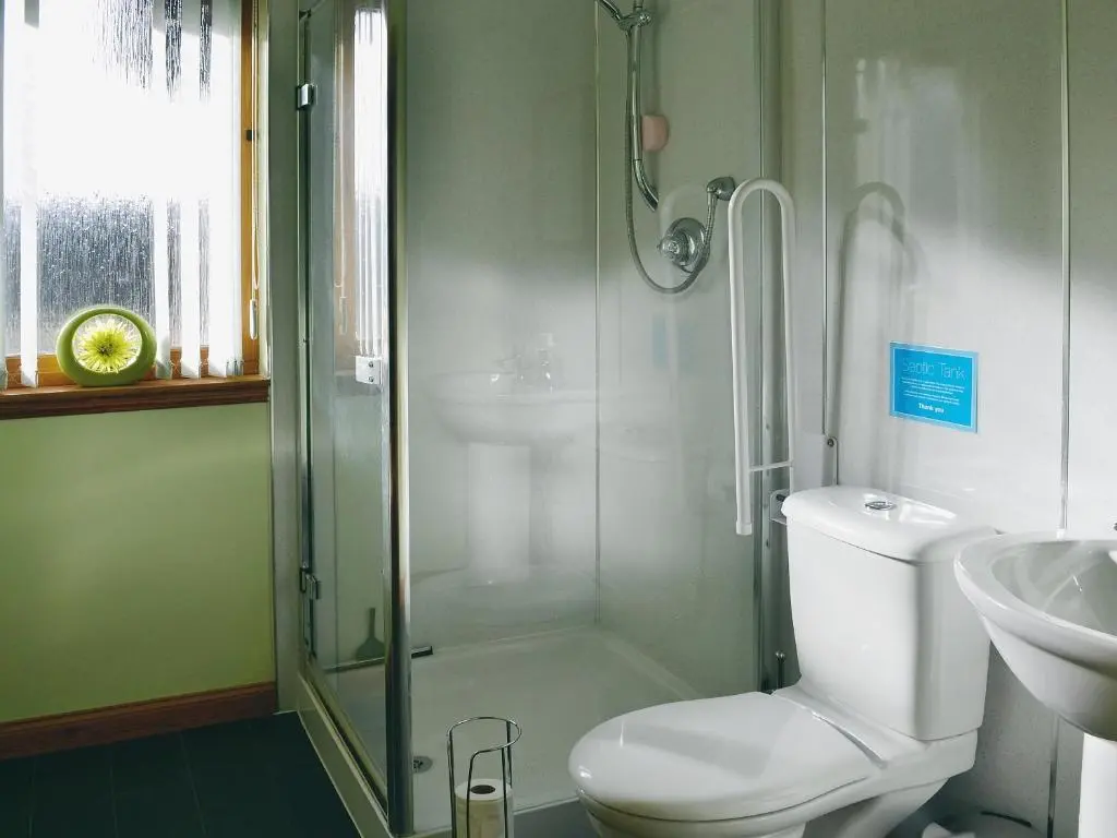 a bathroom with a shower and a toilet and a sink at Park Lodge in Strachan