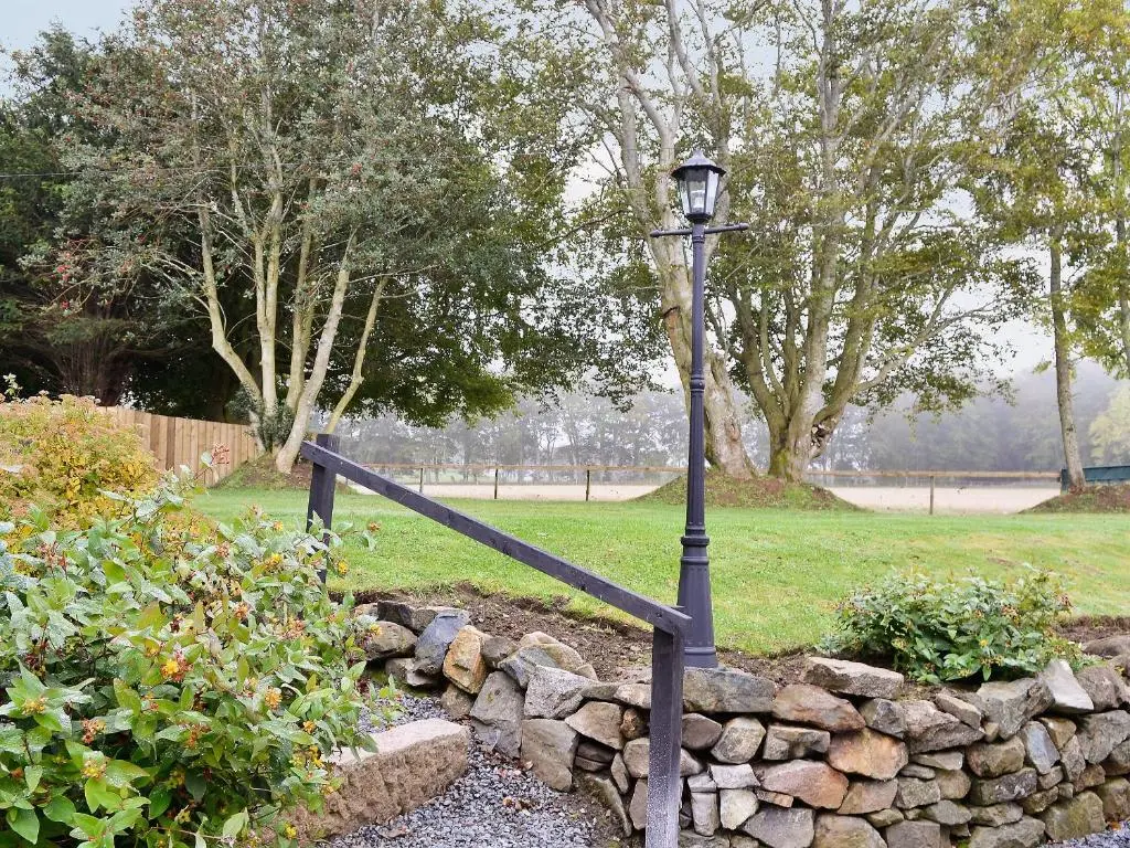 a street light next to a stone wall at Longcroft Cottage - 28233 in Old Rayne