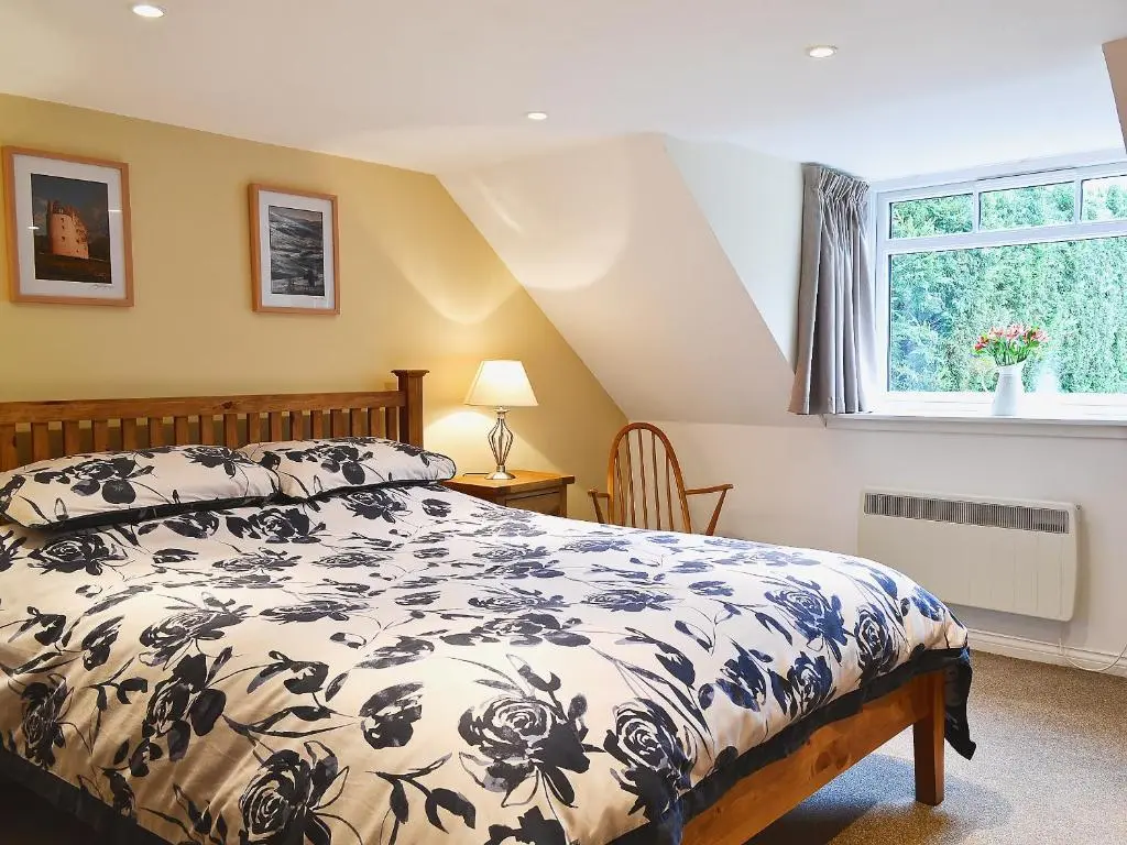 a bedroom with a bed and a window at Longcroft Cottage - 28233 in Old Rayne