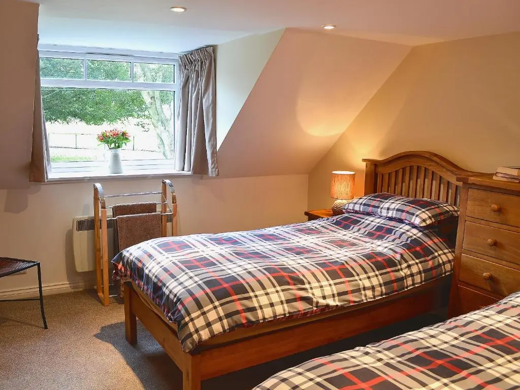 a bedroom with two beds and a window at Longcroft Cottage - 28233 in Old Rayne