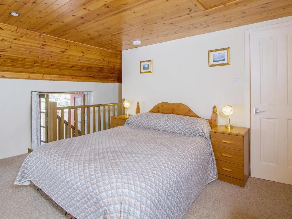 a bedroom with a bed and a wooden ceiling at The Old Laundry in Balnaboth