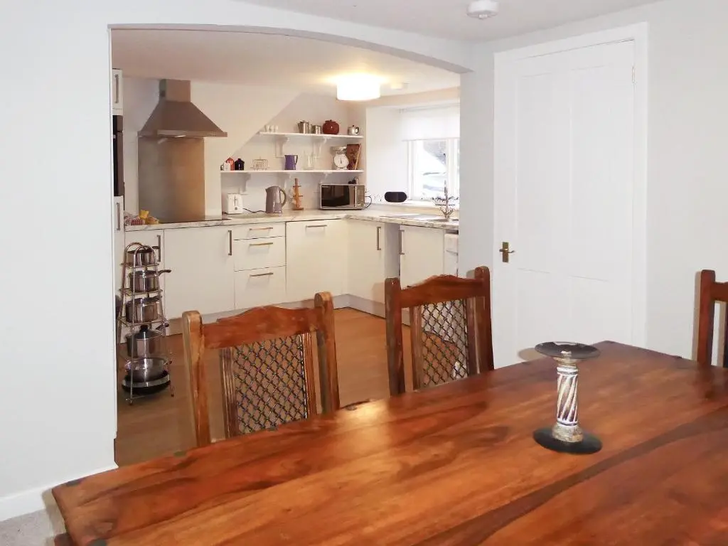 a kitchen and dining room with a wooden table at The White House in Pitlochry